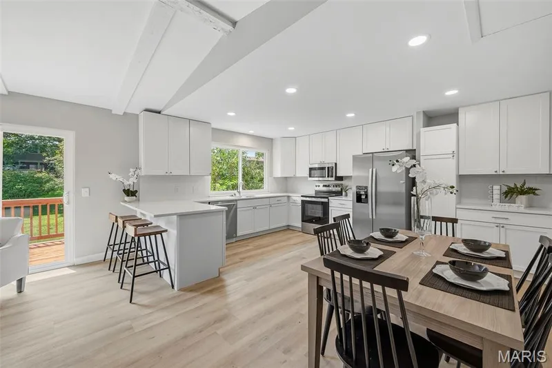 Inviting breakfast room opens to the kitchen and living room, with a sliding glass door leading to the deck and level, fenced backyard. — 3034 Willow Wood Drive, St Charles, MO 63303