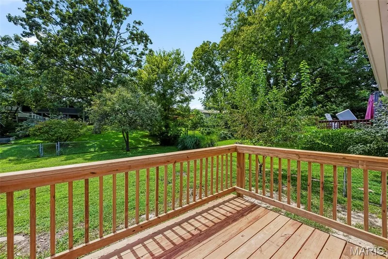 Wood deck off the breakfast room features stairs leading to a level, fenced backyard. — 3034 Willow Wood Drive, St Charles, MO 63303
