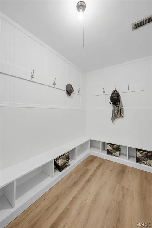 Convenient mud room off the garage features LVP flooring, a boot bench, and built in cubbies with hooks for organized storage. — 3034 Willow Wood Drive, St Charles, MO 63303