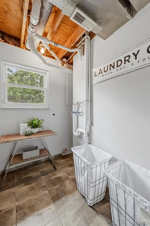 A bright and functional laundry room is conveniently located off the garage and features a window for natural light. — 3034 Willow Wood Drive, St Charles, MO 63303