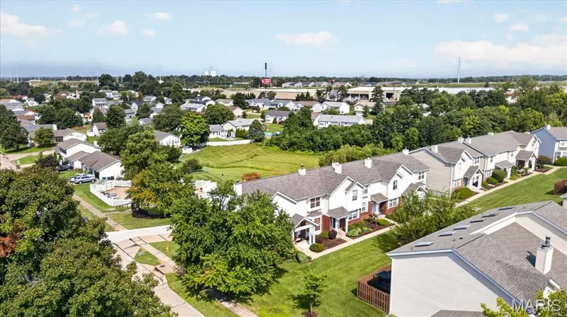 Aerial perspective showcasing multiple properties with uniform gabled roofs, landscaped front yards, and mature trees — 1383 Forest Creek Drive #5, St Charles, MO 63303