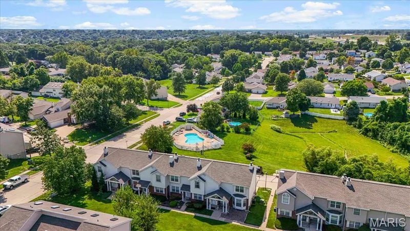 Townhome community with multiple residential buildings, manicured landscaping, and mature trees — 1383 Forest Creek Drive #5, St Charles, MO 63303