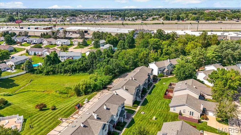 Aerial perspective showcasing residential properties with established landscaping and surrounding green spaces — 1383 Forest Creek Drive #5, St Charles, MO 63303