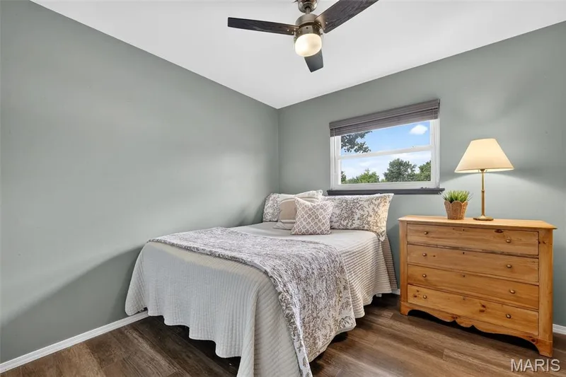 Wood-finish flooring, light gray wall paint, window with blinds, and a ceiling fan with integrated lighting — 402 Saint Joseph Avenue, St Charles, MO 63366