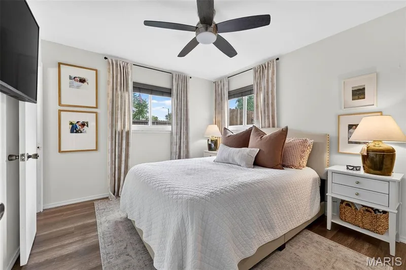 Wood-finish flooring, white walls, two windows with blinds, and a ceiling fan with integrated lighting — 402 Saint Joseph Avenue, St Charles, MO 63366