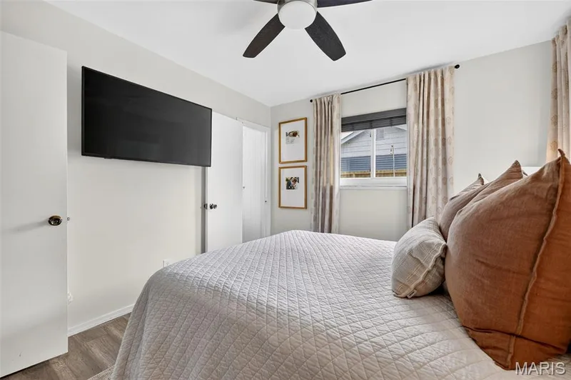 Recessed window, wood-finish flooring, ceiling fan, white paneled doors, and wall-mounted television — 402 Saint Joseph Avenue, St Charles, MO 63366