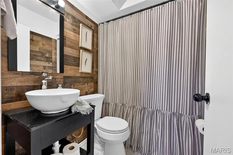 Vanity with vessel sink, wood-finish accent wall, and chrome faucet — 402 Saint Joseph Avenue, St Charles, MO 63366