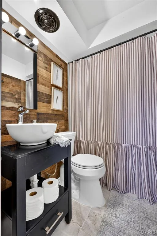 Wood-finish accent wall with a vessel sink vanity and a white toilet — 402 Saint Joseph Avenue, St Charles, MO 63366