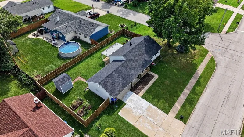 Expansive corner lot with mature trees, established landscaping, and a fenced backyard — 402 Saint Joseph Avenue, St Charles, MO 63366