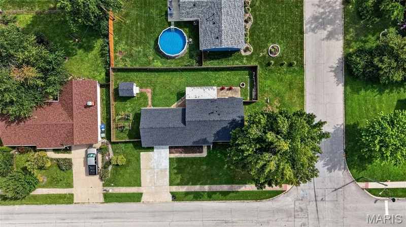Manicured front yard with mature trees, paved driveway, spacious backyard, and an outdoor storage shed — 402 Saint Joseph Avenue, St Charles, MO 63366