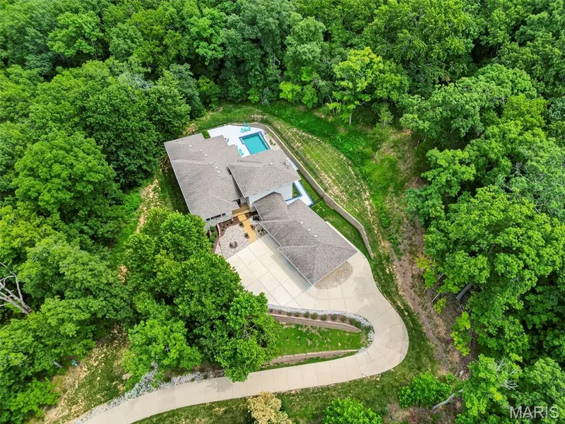 Extensive surrounding greenery, private swimming pool, multi-level dwelling, concrete driveway, and outdoor patio space — 19256 Saint Albans Forest Lane, Wildwood, MO 63038