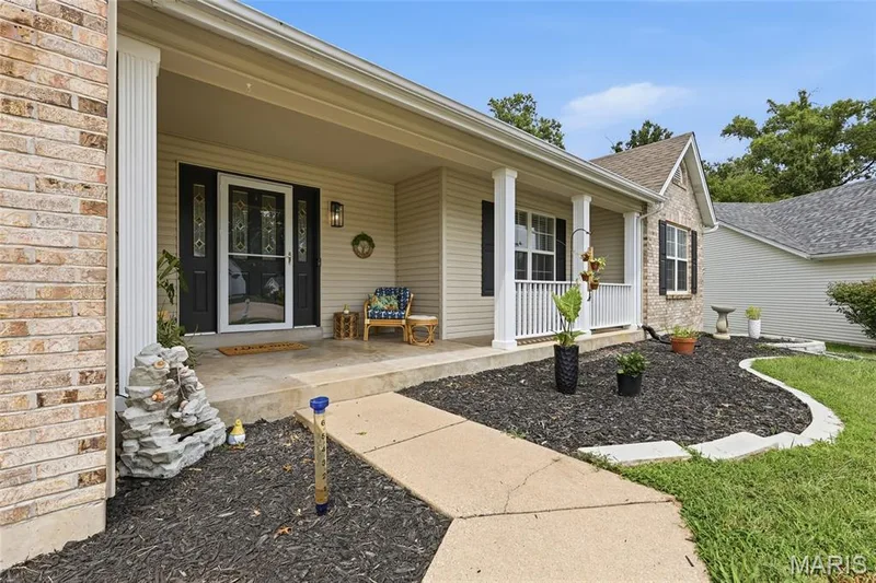 Covered front porch featuring white columns and railing — 1094 Treeshade Drive, St Peters, MO 63376