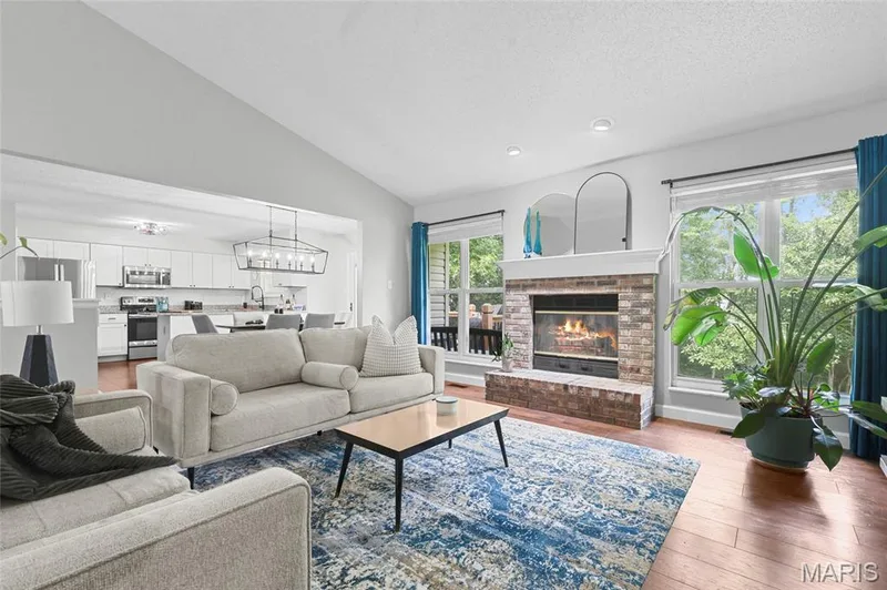 Wood-finish flooring throughout, brick fireplace with a white mantel, and recessed lighting — 1094 Treeshade Drive, St Peters, MO 63376