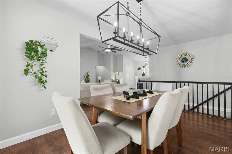 Vaulted ceiling, wood-finish flooring, and a linear chandelier with multiple candelabra-style lights — 1094 Treeshade Drive, St Peters, MO 63376