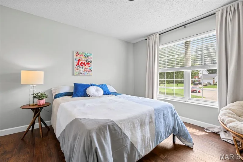 Wood-finish flooring with light gray walls, large window with blinds, and white trim — 1094 Treeshade Drive, St Peters, MO 63376