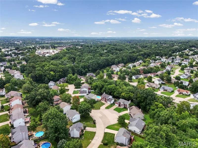 Expansive residential area featuring numerous single-family homes, mature trees, and paved roads — 1094 Treeshade Drive, St Peters, MO 63376