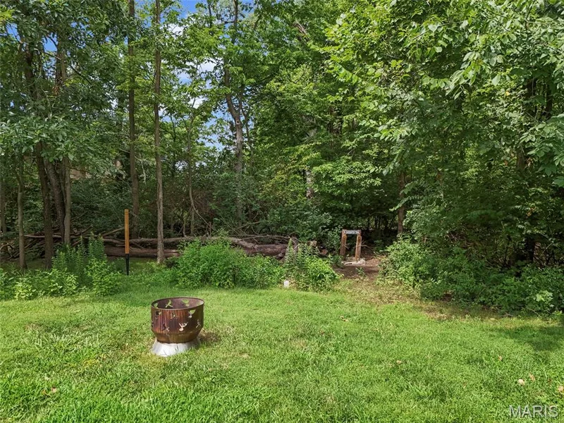 Expansive grassy area surrounded by mature trees — 1094 Treeshade Drive, St Peters, MO 63376