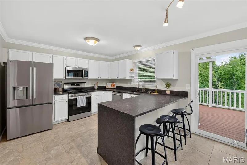 Updated kitchen has newer SS appliances, textured granite countertops, newer grouted luxury flooring and breakfast bar. — 1761 Fairview Farms Circle, Wentzville, MO 63385