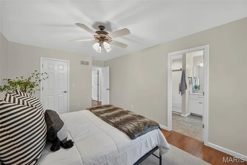 Primary bedroom has hardwood flooring, ceiling fan and walk-in closet. — 1761 Fairview Farms Circle, Wentzville, MO 63385