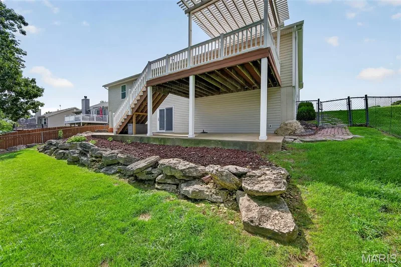 Attractive natural stone landscaping and a rock retaining wall add character to the yard, with plenty of green space to enjoy. — 1761 Fairview Farms Circle, Wentzville, MO 63385