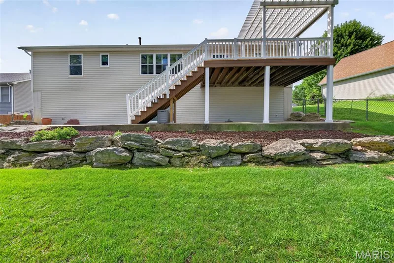 Attractive natural stone landscaping and a rock retaining wall add character to the yard, with plenty of green space to enjoy. — 1761 Fairview Farms Circle, Wentzville, MO 63385