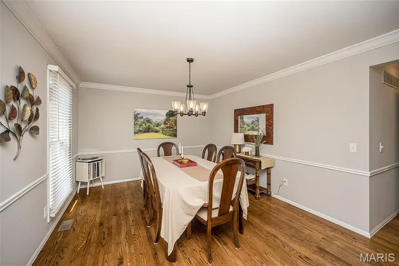 Dining room with beautiful hardwood floors and crown molding — 15706 Heathercroft Drive, Chesterfield, MO 63017