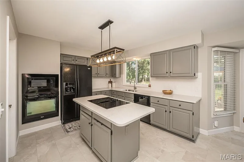 Kitchen island with Quartz countertops and updated lighting fixtures — 15706 Heathercroft Drive, Chesterfield, MO 63017