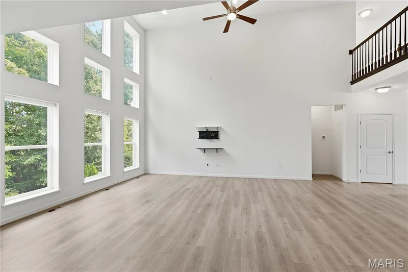 High ceilings, wood flooring, abundant windows, ceiling fan with light, and a second-story overlook with wood railing — 1278 Harvester Drive, Chesterfield, MO 63005