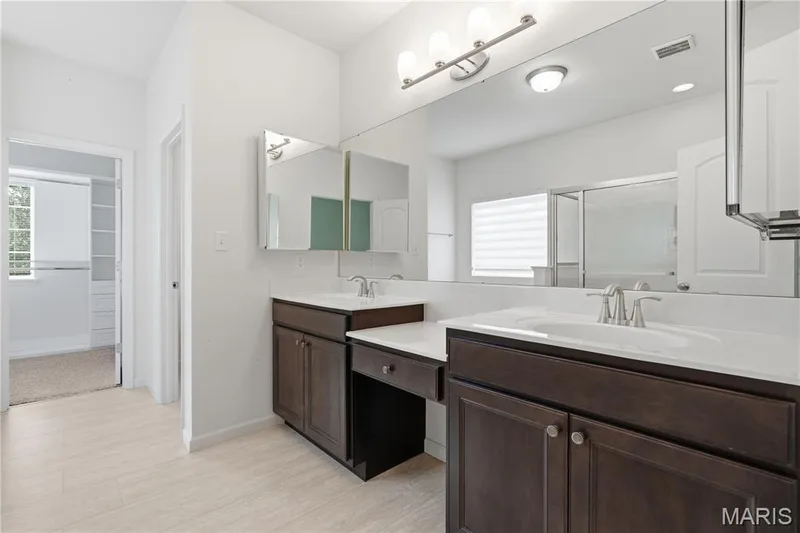 Luxury bath has dual vanity with dark wood-finish cabinetry, and upgraded medicine cabinets — 1278 Harvester Drive, Chesterfield, MO 63005