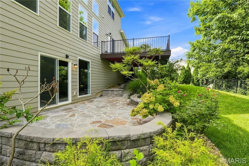 Beautiful flagstone patio with decorative lighting and seating wall — 1278 Harvester Drive, Chesterfield, MO 63005