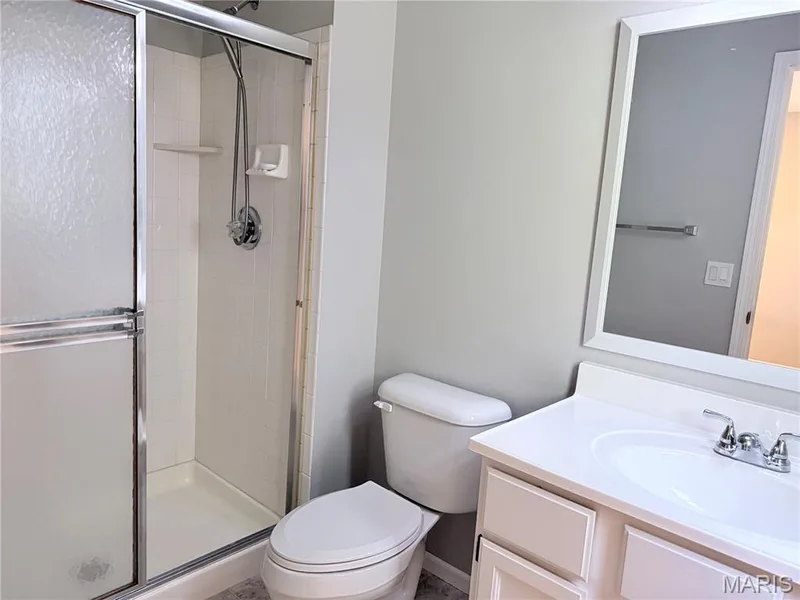 Shower with sliding glass enclosure, white tile surround, and a chrome shower head — 21 White Chapel, O'Fallon, MO 63368