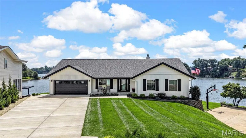 Picture-perfect lakefront living with beautiful curb appeal, lush landscaping and breathtaking Lake Saint Louis views.  Click on the two videos for more! — 22 Harbor Point Court, Lake St. Louis, MO 63367