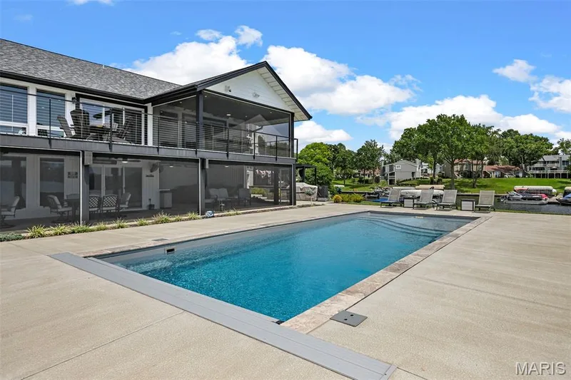 Resort-style outdoor living with a beautiful private pool, expansive patio and multiple screened living spaces overlooking the lake. — 22 Harbor Point Court, Lake St. Louis, MO 63367