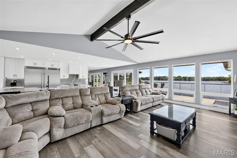 The heart of the home—an impressive Great Room with soaring ceilings, architectural beams and a wall of windows framing spectacular lake views. Cabled wire railing adds to the amazing view with little or no obstruction. — 22 Harbor Point Court, Lake St. Louis, MO 63367
