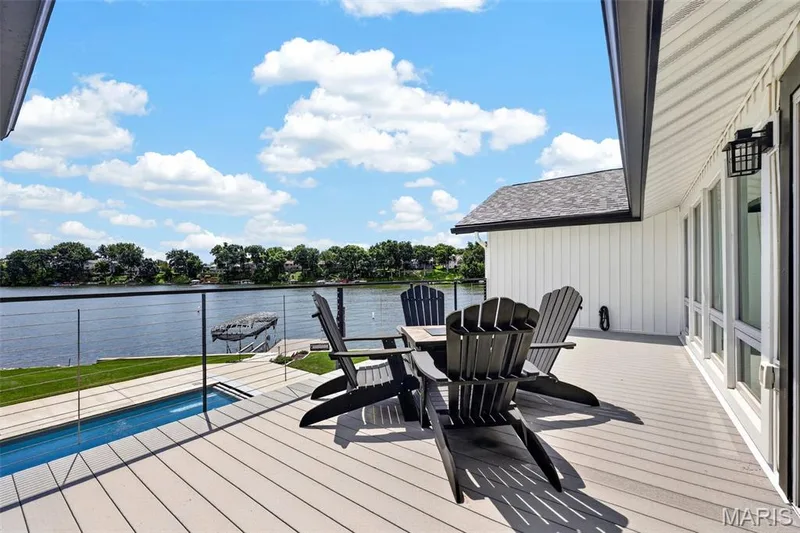 Your front-row seat to lake life—an expansive deck overlooking the pool and water, perfect for morning coffee, sunset cocktails or simply taking in the view. — 22 Harbor Point Court, Lake St. Louis, MO 63367