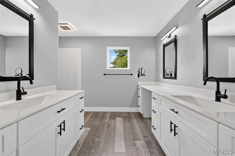 A beautifully appointed Primary Bath featuring dual vanity areas, abundant cabinetry, generous counter space and sophisticated modern finishes. — 22 Harbor Point Court, Lake St. Louis, MO 63367