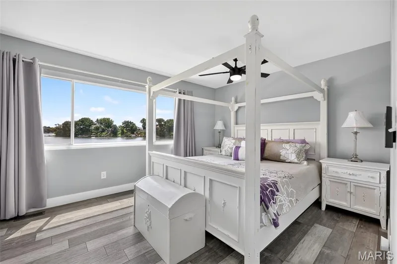Wake up to the lake—an inviting Primary Bedroom where expansive windows frame beautiful water views and fill the room with natural light. — 22 Harbor Point Court, Lake St. Louis, MO 63367