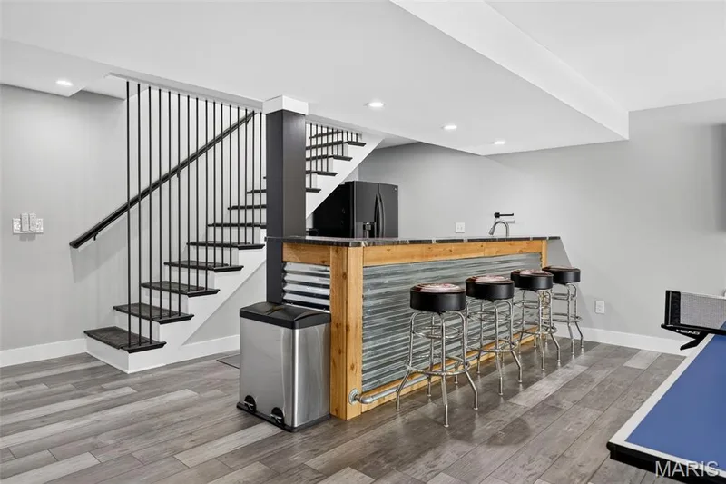 Ready for entertaining—a custom lower-level bar creates the perfect gathering spot for friends and family after a day on the lake. — 22 Harbor Point Court, Lake St. Louis, MO 63367