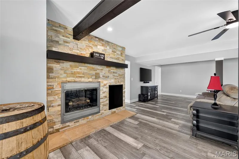 Cozy meets entertaining in the finished lower level, highlighted by a beautiful stone-accented, fully functioning wood-burning fireplace. It is currently electric. — 22 Harbor Point Court, Lake St. Louis, MO 63367