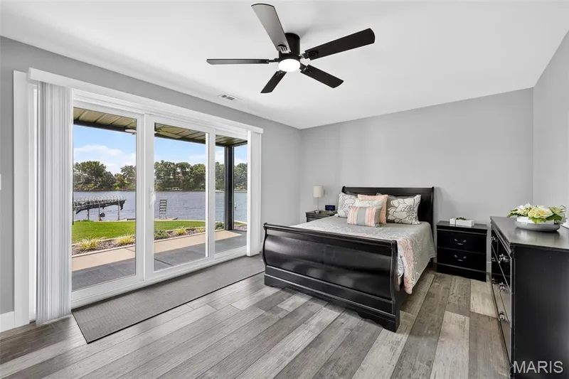 Guests may never want to leave—this inviting lower-level bedroom features a sliding glass door with direct outdoor access and beautiful views of the lake. — 22 Harbor Point Court, Lake St. Louis, MO 63367