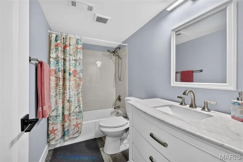 Conveniently located lower-level full bath featuring an updated vanity and tub/shower combination—perfect for guests after a day on the lake. — 22 Harbor Point Court, Lake St. Louis, MO 63367