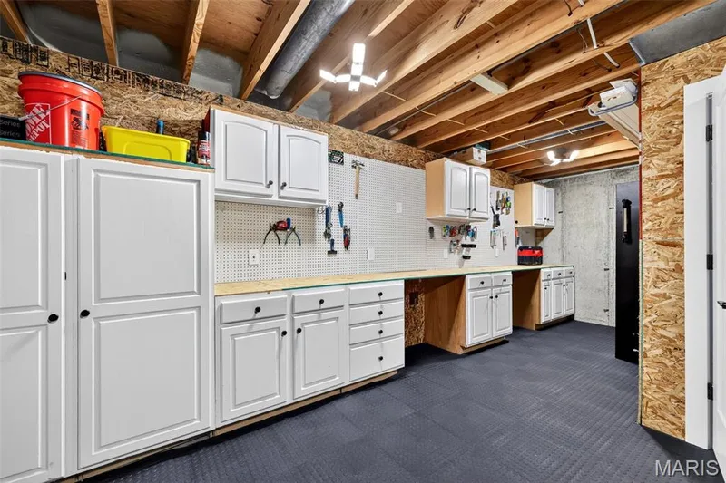 A place for everything—dedicated workshop and utility space with extensive cabinetry, work surfaces and plenty of room for tools, projects and lake gear. — 22 Harbor Point Court, Lake St. Louis, MO 63367