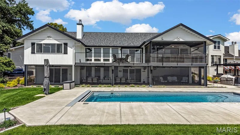 Designed for lakefront living—an impressive rear elevation showcasing the private pool, expansive deck and multiple screened outdoor living spaces for year-round enjoyment. — 22 Harbor Point Court, Lake St. Louis, MO 63367