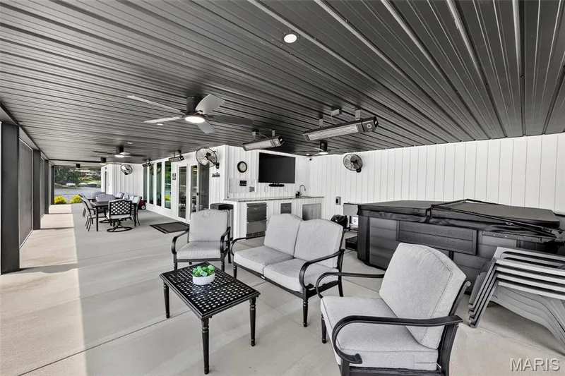 Expansive Covered Outdoor Living Area Designed for Year-Round Enjoyment! Features a Hot Tub, Outdoor Kitchen, Multiple Overhead Heaters, Ceiling and Wall Fans, TV and Plenty of Space for Dining and Entertaining all screened in and all just steps from the Pool and Lake! — 22 Harbor Point Court, Lake St. Louis, MO 63367