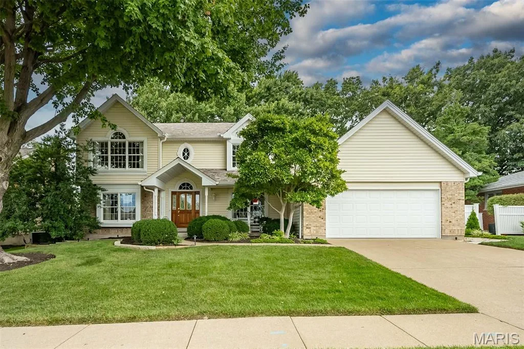 Traditional-style residence featuring light-colored siding and brick accents — 1551 Country Bend Drive, St Charles, MO 63303