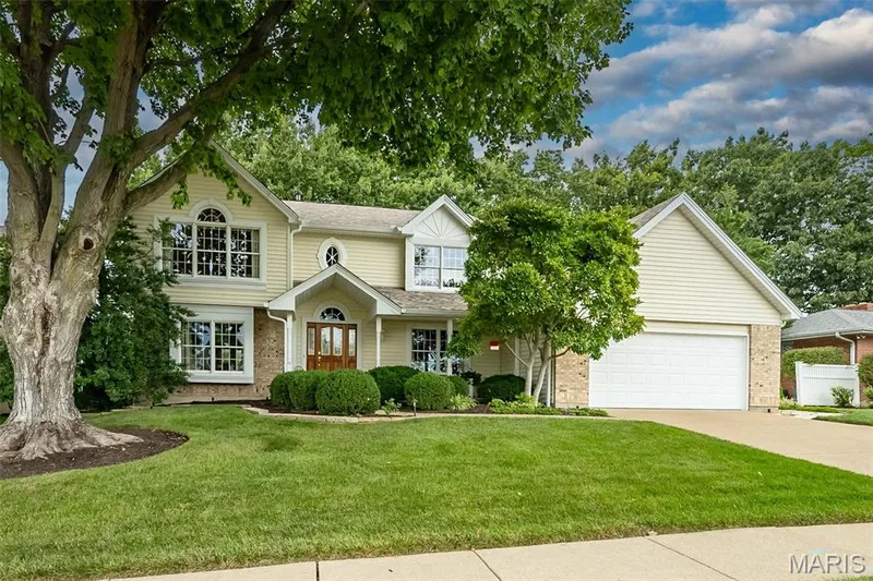 Light yellow siding exterior with a prominent two-car garage — 1551 Country Bend Drive, St Charles, MO 63303