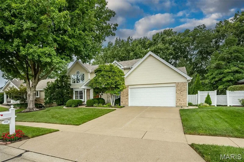Two-story residence with a light-colored brick facade, light siding, and a gabled roofline — 1551 Country Bend Drive, St Charles, MO 63303