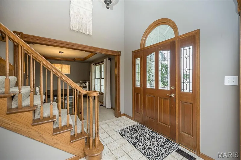 Wood-paneled front door with leaded glass sidelights and transom window — 1551 Country Bend Drive, St Charles, MO 63303