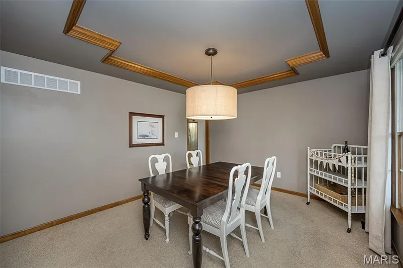 Recessed ceiling with decorative wood trim, neutral wall paint, and suspended drum pendant lighting — 1551 Country Bend Drive, St Charles, MO 63303