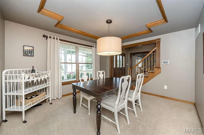 Tray ceiling with wood trim accents, drum pendant light fixture, and carpet flooring — 1551 Country Bend Drive, St Charles, MO 63303
